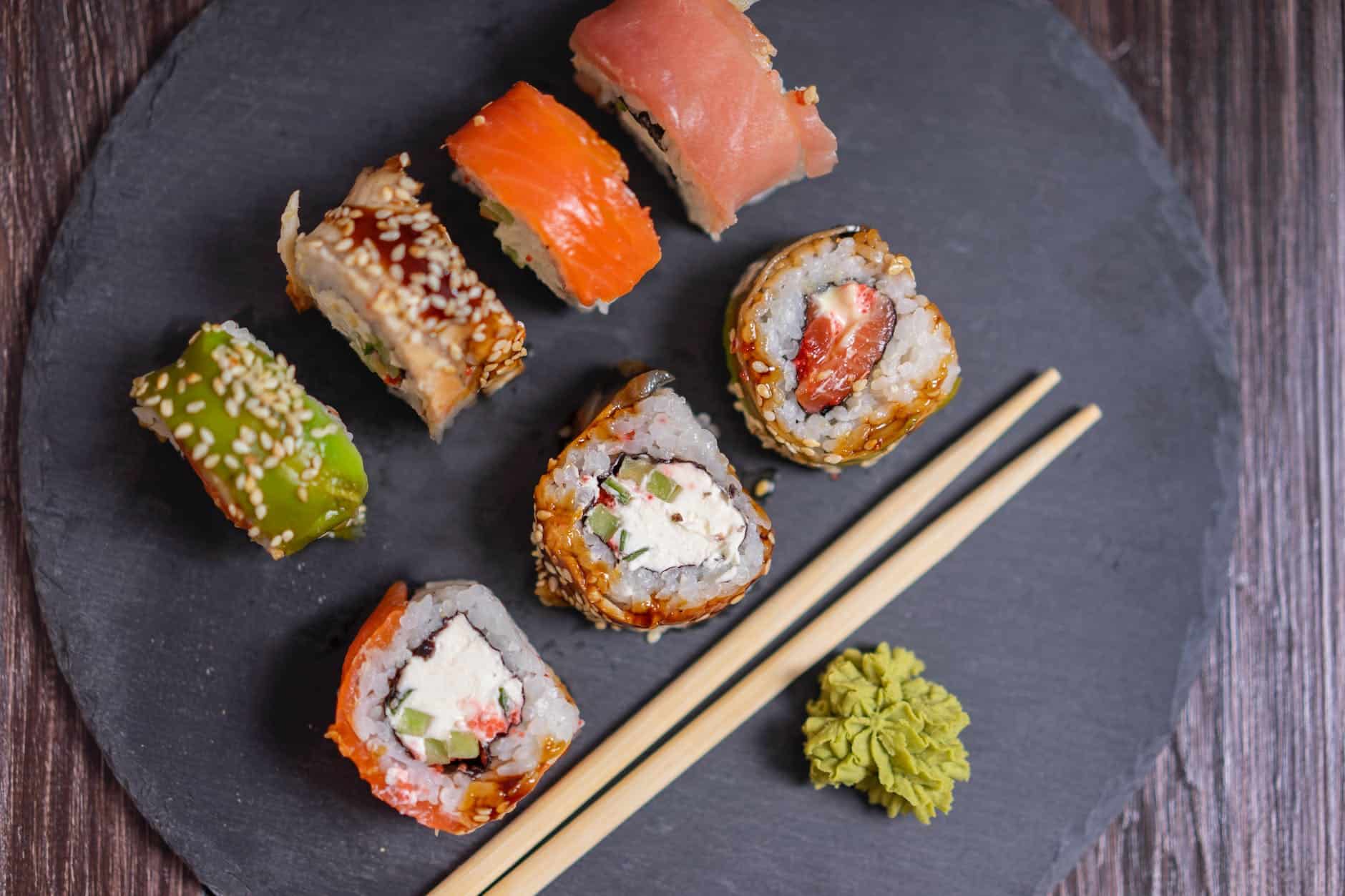 sushi rolls on black wooden tray