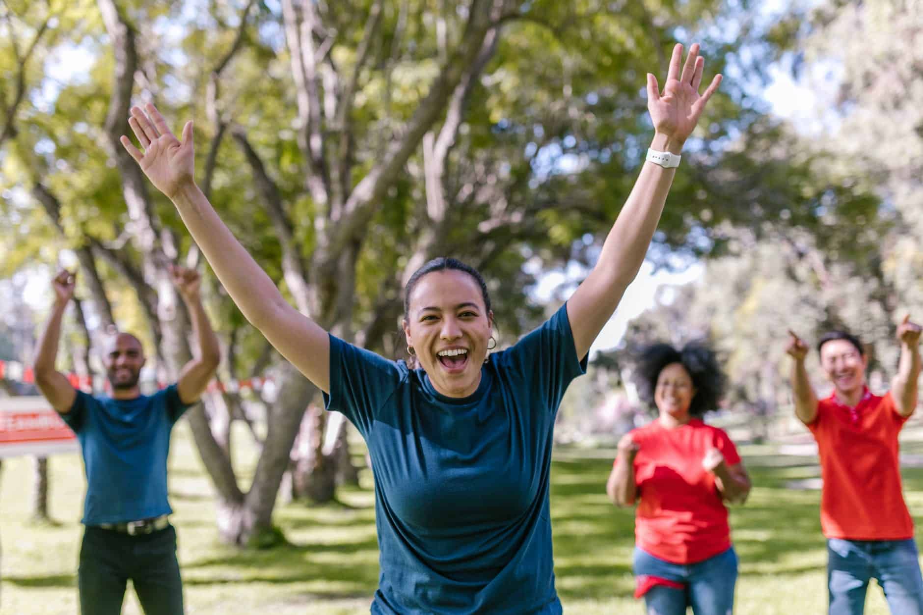 woman in blue crew neck t shirt raising her hands